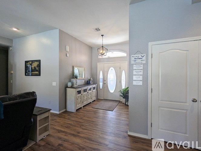 A living room with a couch, a chair, and a cabinet with a mirror.