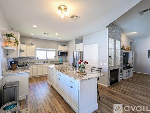 A kitchen with white cabinets and a granite countertop.