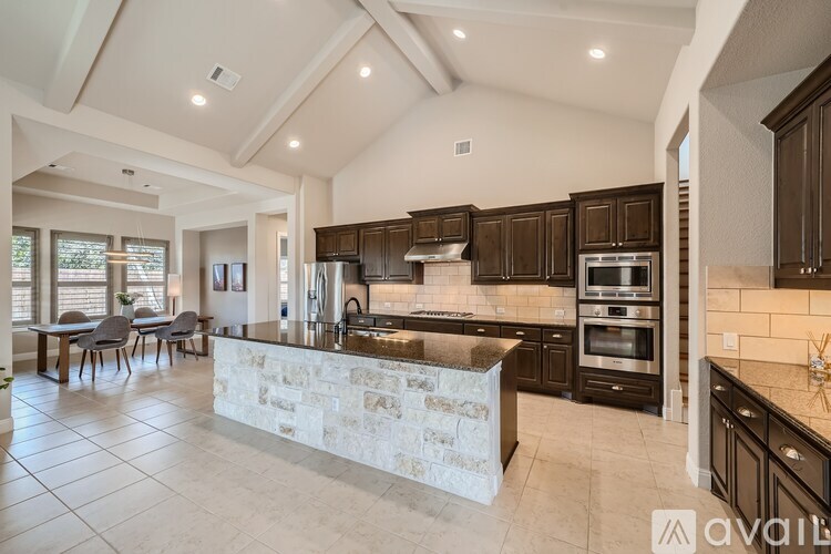 A modern kitchen with a stone island in the middle.