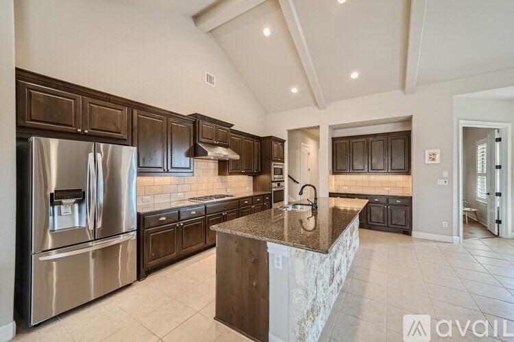 A kitchen with a marble island and stainless steel appliances.
