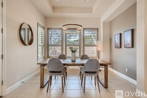 A dining room with a table and chairs.