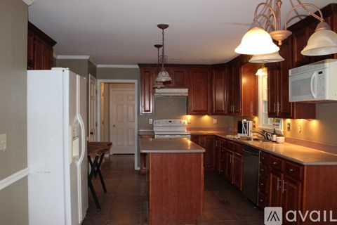 A kitchen with a white refrigerator and wooden cabinets.