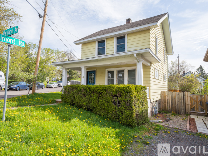 A house with a yellow front and a green lawn.