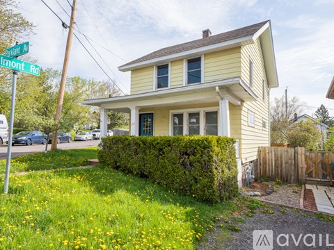 A house with a yellow front and a green lawn.
