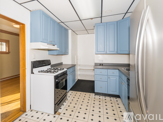 A kitchen with blue cabinets and a white refrigerator.
