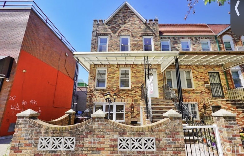 A red building with a white fence in front.