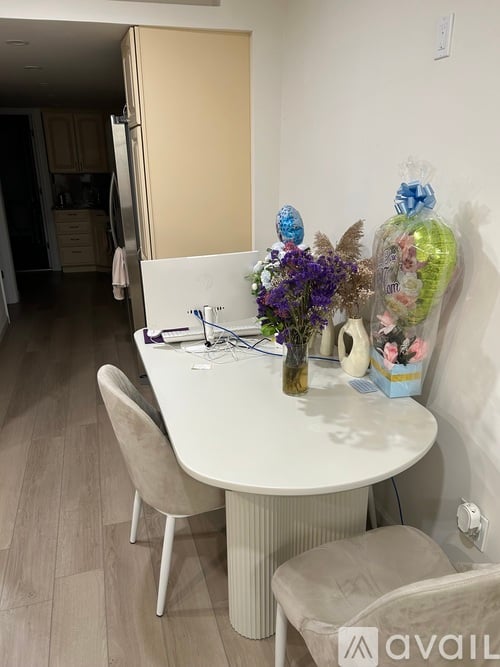 A small table with chairs and a vase of flowers.