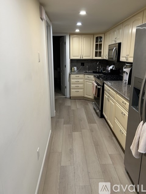 A kitchen with a refrigerator, microwave, and oven.