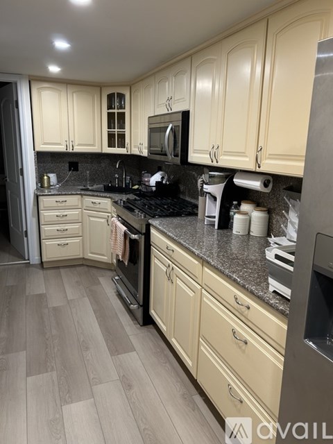 A kitchen with wooden cabinets and a black countertop.