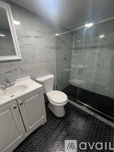 A bathroom with a toilet, sink, and walk-in shower.