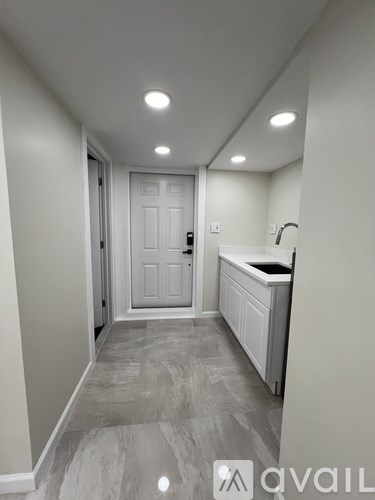 A hallway with a white door and a counter on the right side.
