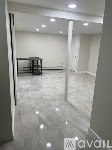 A spacious room with a table and chairs in the center.