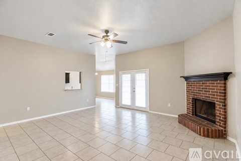 A living room with a fireplace and a ceiling fan.