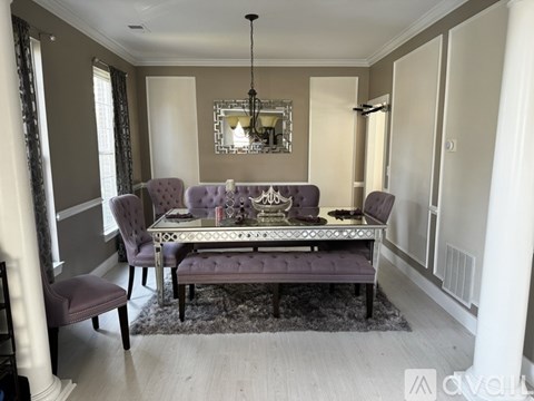 A dining room with a purple table and chairs.
