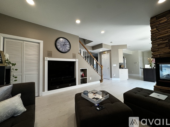 A living room with a black couch and a fireplace.