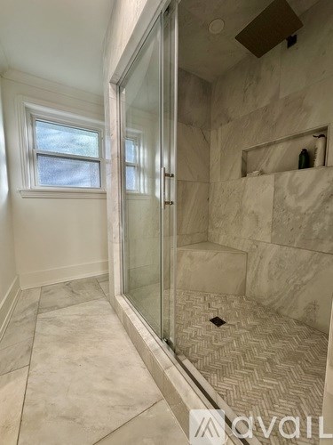 A bathroom with a walk-in shower and a window.