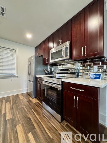 A kitchen with dark wood cabinets and stainless steel appliances.