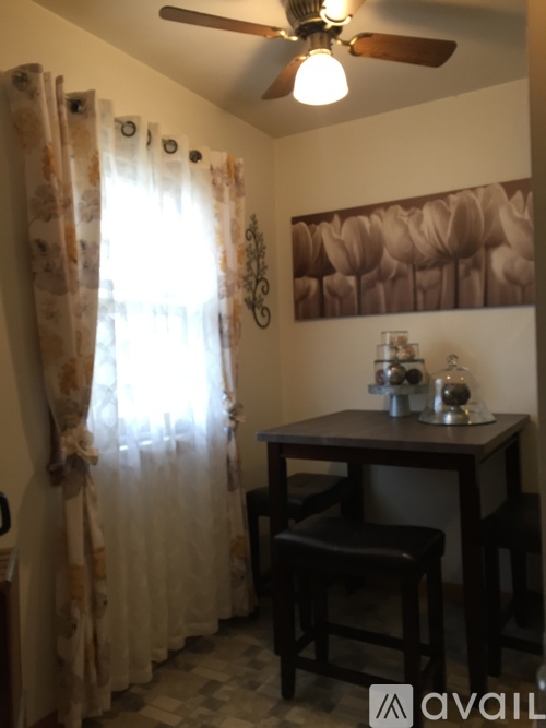 A room with a table and chairs and a fan.