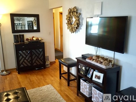 A black television is on a stand in a living room.