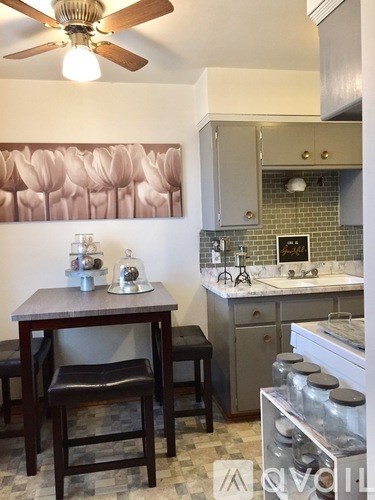 A kitchen with a table and chairs.