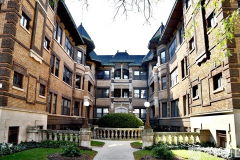A courtyard surrounded by buildings with a walkway in the middle.