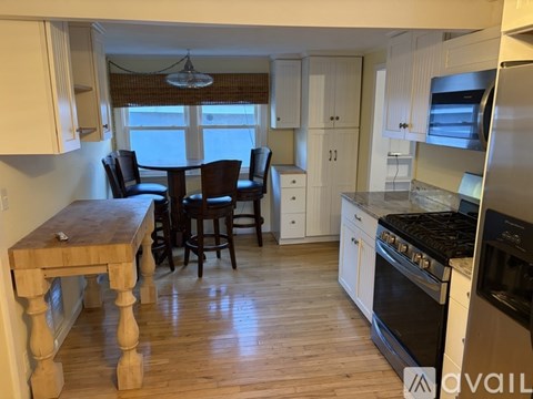A kitchen with a dining table and chairs.