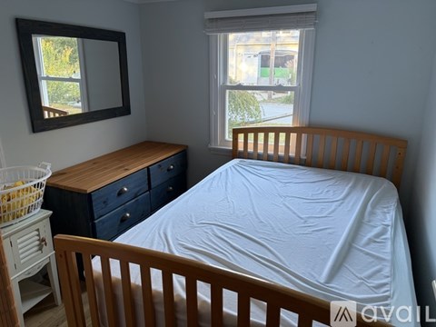 A bedroom with a bed, dresser, and mirror.