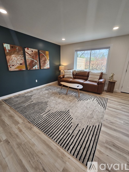 A living room with a brown leather couch and a rug with a heart design.