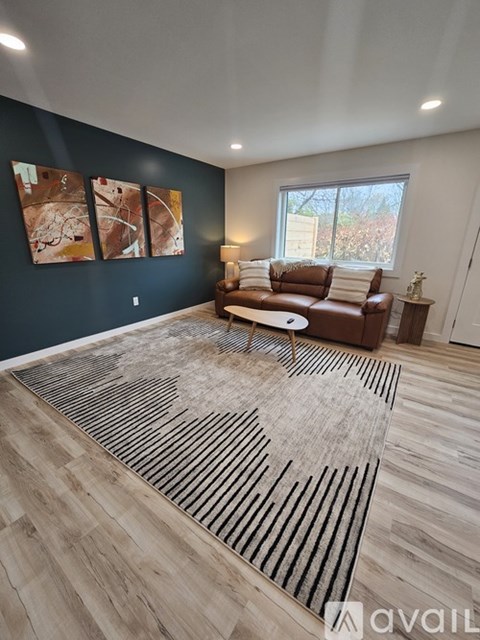 A living room with a brown leather couch and a rug with a heart design.