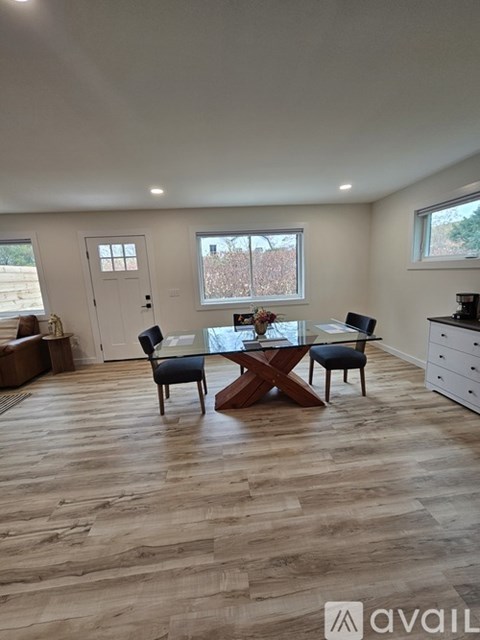 A dining room with a table and chairs.