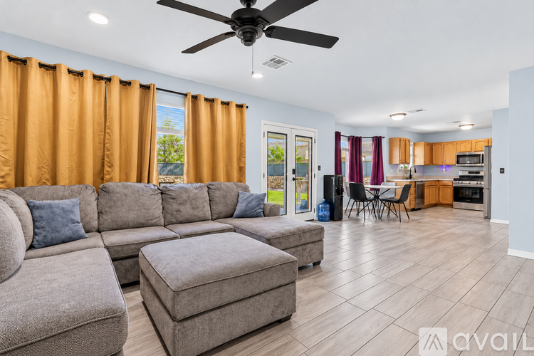 A living room with a grey sofa and a ceiling fan.