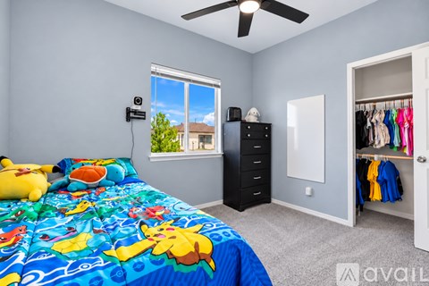 A bedroom with a bed, dresser, and a window with a view of a house and trees.