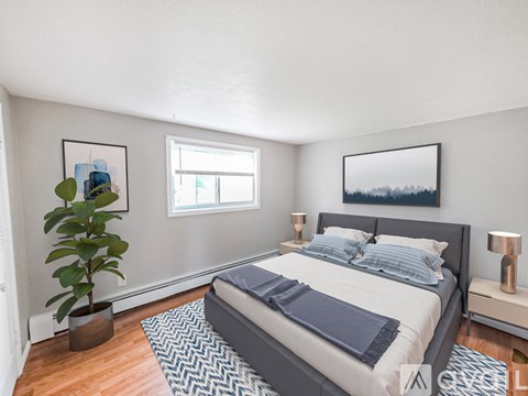 A bedroom with a large bed and a potted plant.