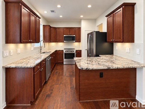 A kitchen with wooden cabinets and granite countertops.