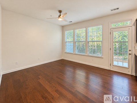 A room with wooden floors and a ceiling fan.
