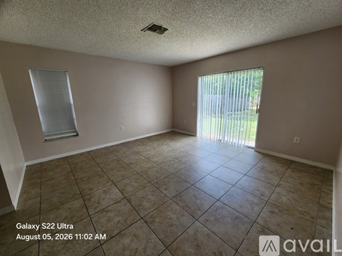 A room with tiled flooring and a window with blinds.