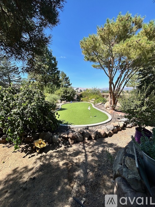 A miniature golf course surrounded by trees and rocks.