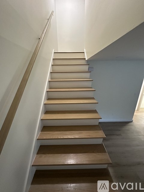 A staircase with wooden steps and a metal handrail.