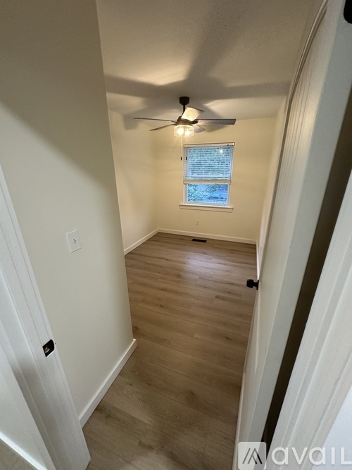 A room with a ceiling fan and a window with blinds.