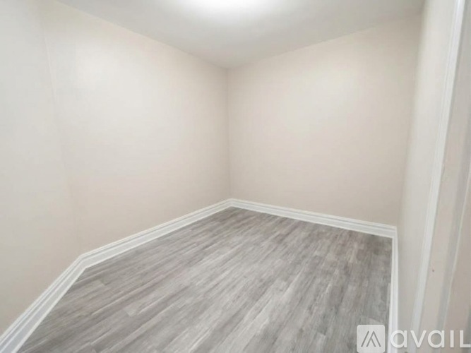 A room with wooden flooring and white walls.