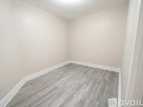 A room with wooden flooring and white walls.