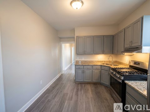 A kitchen with a stove top oven and cabinets.