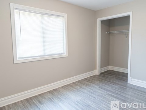 A room with a window and a closet.