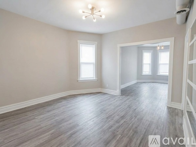 A room with wooden flooring and a chandelier.