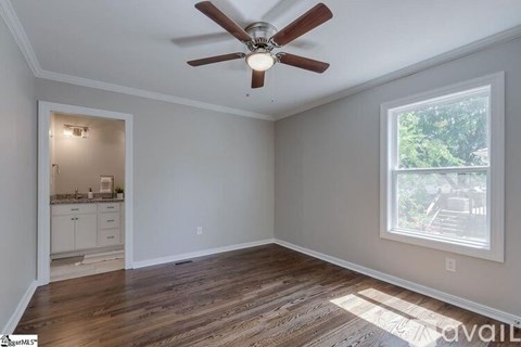A room with a ceiling fan and a window.