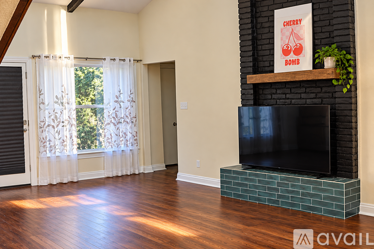 A living room with a fireplace and a poster on the wall.