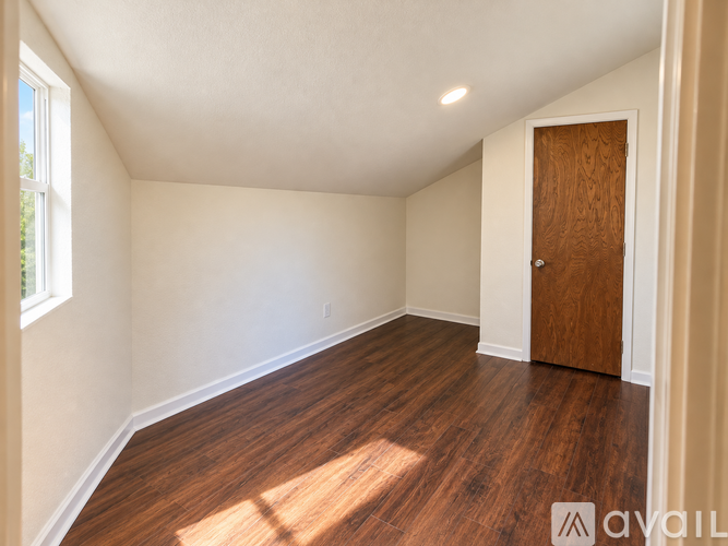 A room with wooden flooring and a door.