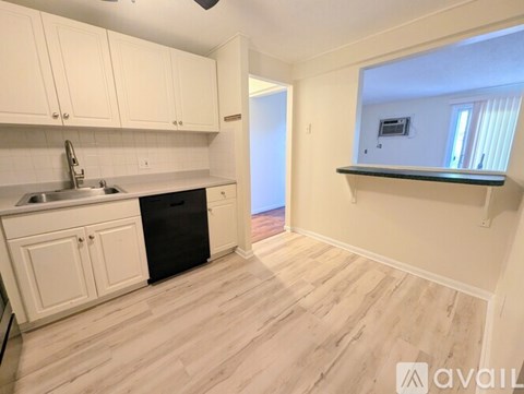 A kitchen with white cabinets and a black dishwasher.