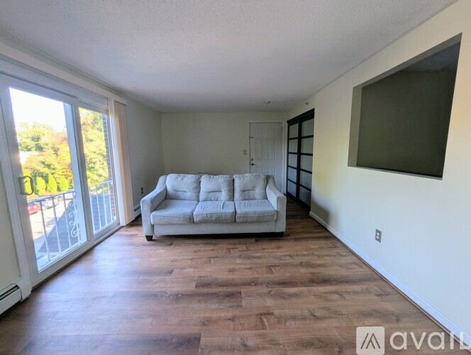 A living room with a white couch and wooden floors.