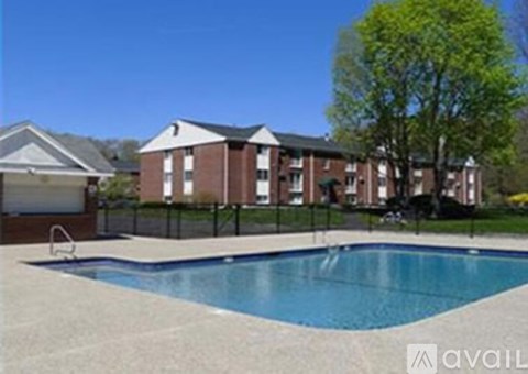 A swimming pool in front of a building with a tree in the background.